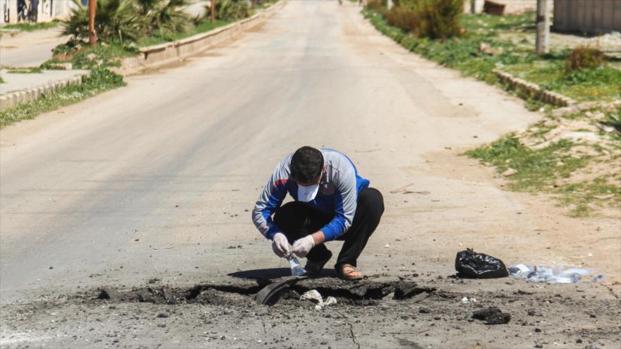 Un investigador local examina los restos de un contenedor de gas químico Sarín en Jan Sheijun, en la provincia siria de Idlib.
