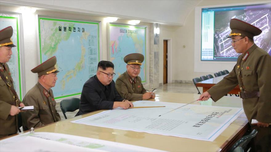 El líder norcoreano, Kim Jong-un (centro) junto a altos mandos militares, estudia unos planos.