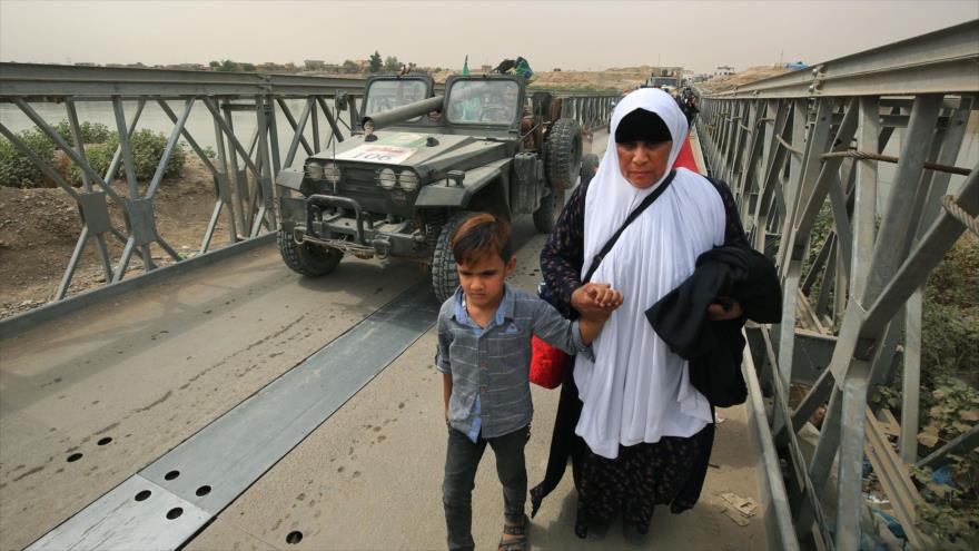Civiles iraquíes cruzan un puente mientras las fuerzas iraquíes avanzan hacia la ciudad de Al-Sharqat, 20 de septiembre de 2017.