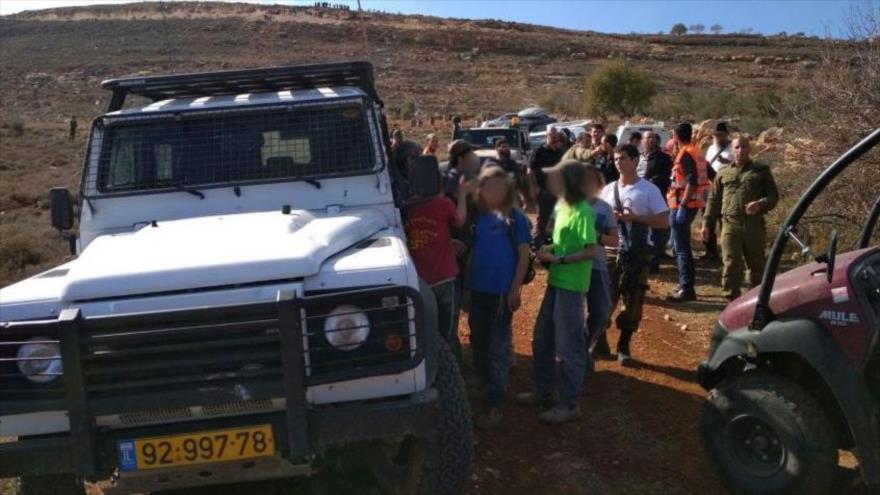Policía y colonos israelíes congregados cerca de la aldea de Qusra, en la Cisjordania ocupada, 30 de noviembre de 2017.