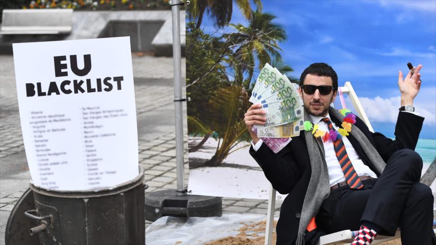 Un activista escenifica un juego de calle satírico imitando a una persona adinerada que oculta su dinero en un paraíso fiscal, 5 de diciembre de 2017.
