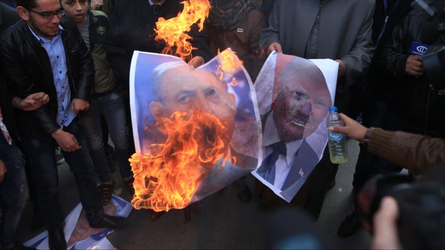 Palestinos queman fotos de Netanyahu y Trump durante una protesta en Gaza, 7 de diciembre de 2017.