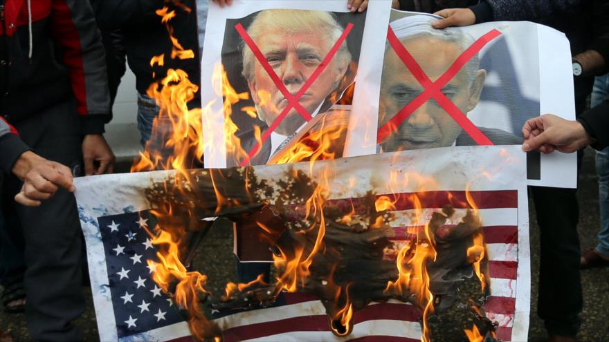 Palestinos queman fotos de Netanyahu y Trump durante una protesta en Gaza, 7 de diciembre de 2017.