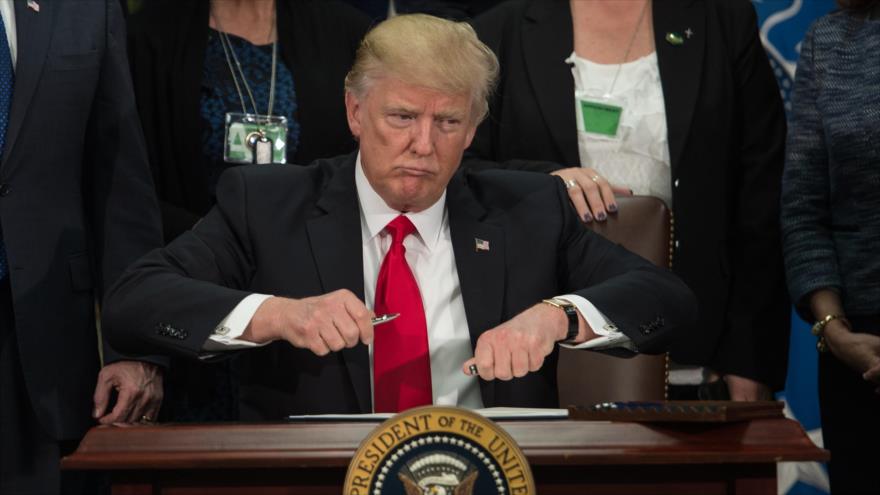 El presidente de EE.UU., Donald Trump, firmando un documento en la Casa Blanca, 25 de enero de 2017.