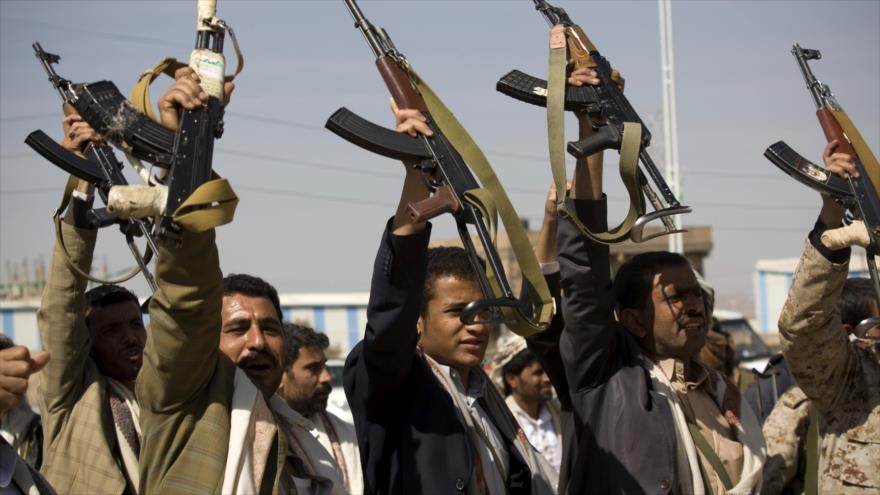 Miembros del movimiento popular yemení Ansarolá alzan sus armas en Saná, capital de Yemen.