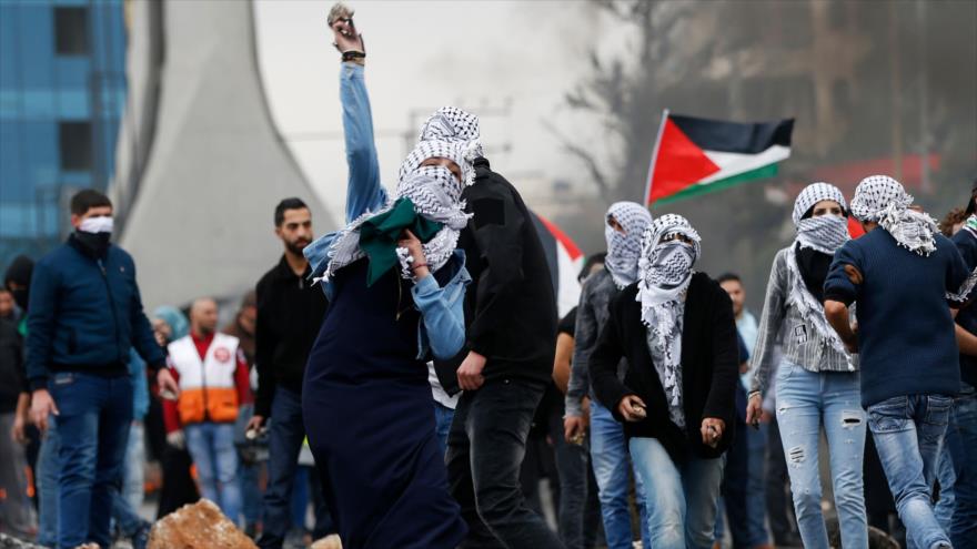 Palestinos ondean su bandera en una protesta contra la decisión del presidente de EE.UU., Donald Trump, Ramalá, 13 de diciembre de 2017.