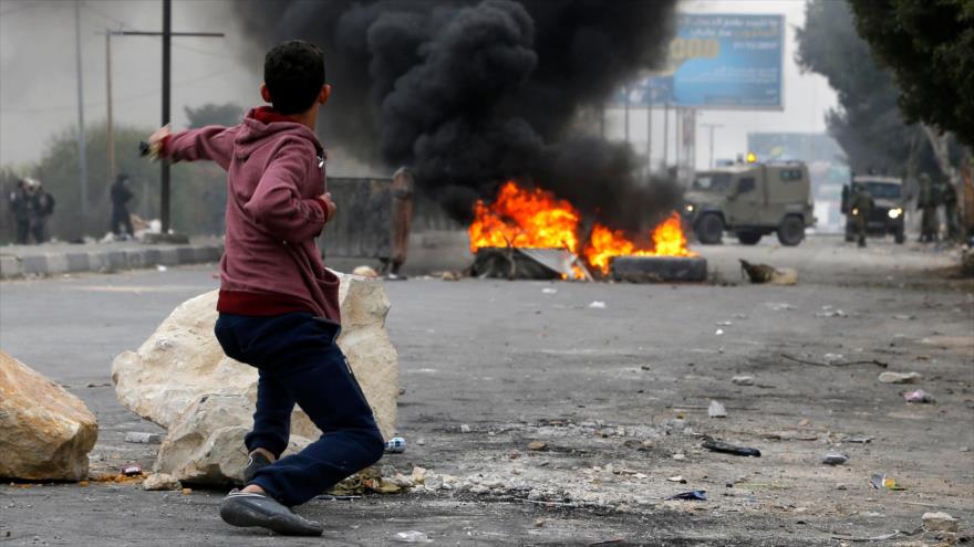 Un manifestante palestino lanza piedras contra las fuerzas israelíes en las protestas registradas en la ciudad cisjordana de Nablus, 22 de diciembre de 2017.