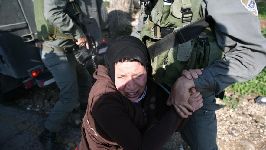 Las fuerzas israelíes, deteniendo a palestinos, durante una protesta contra el muro de separación de Israel en Cisjordania, 22 de enero de 2010.