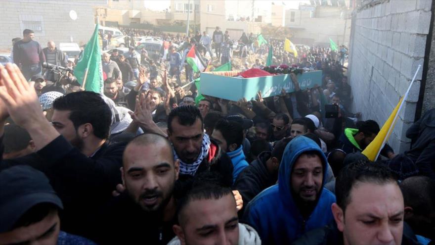 Palestinos participan en el funeral de uno de sus compatriotas caído mártir a manos de soldados israelíes en Al-Quds.