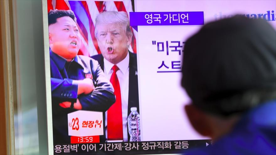 Un hombre ve un programa televisivo que muestra al presidente estadounidense, Donald Trump, (dcha.), y al líder norcoreano, Kim Jong-un, 9 de agosto de 2017.
