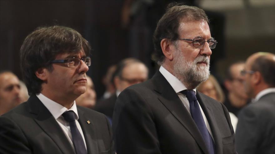 El expresident catalán Carles Puigdemont (izda.) y el presidente del Gobierno español Mariano Rajoy en una ceremonia para conmemorar víctimas de atentados terroristas en Cataluña, 20 de agosto de 2017.
