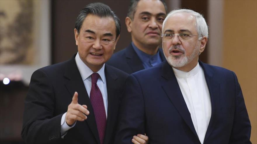 El canciller chino, Wang Yi (izda), y su par iraní, Mohamad Yavad Zarif, llegan para asistir a un conferencia de prensa en Pekín.