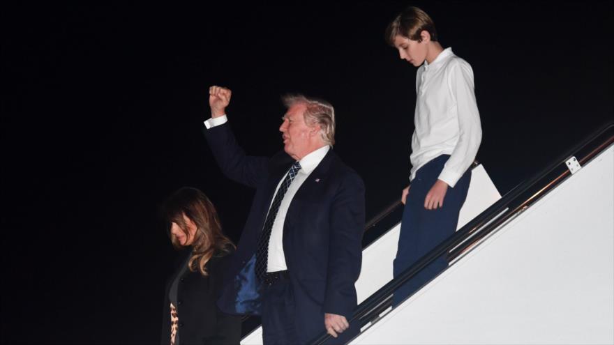 El mandatario de EE.UU.,Donald Trump, baja del avión presidencial en Florida (sureste) junto a su esposa y su hijo, 12 de enero de 2018.