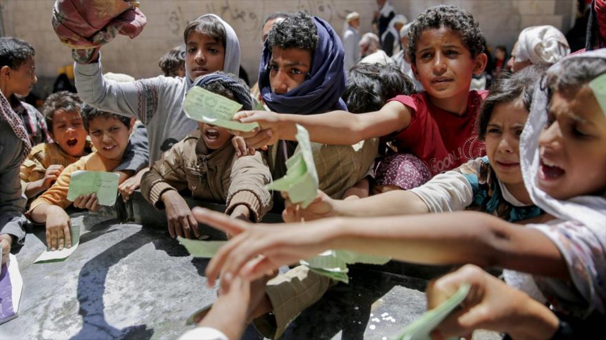 Niños yemeníes presentan documentos para recibir raciones de alimentos, en Saná, capital de Yemen, 13 de abril de 2017.