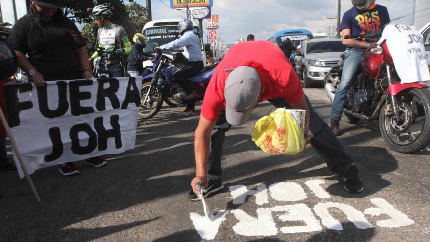 Un manifestante hondureño pinta ‘Fuera JOH’ en una protesta contra el presidente reelecto Juan Orlando Hernández, 12 de enero de 2018.