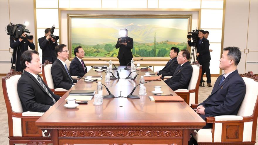 Miembros de las delegaciones de Corea del Sur (izda.) y Corea del Norte (dcha.) reunidos para una ronda de diálogos, 17 de enero de 2018.