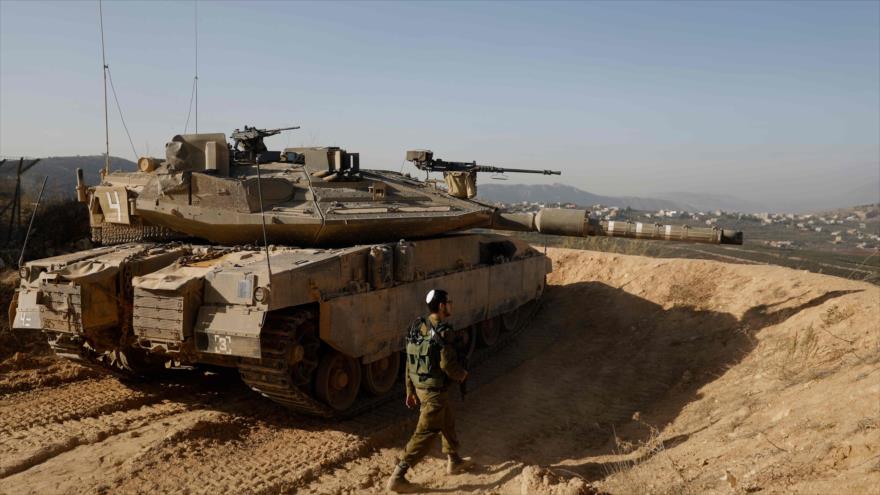 Un soldado israelí camina al lado de un tanque de Israel a lo largo de la frontera con El Líbano, 16 de noviembre de 2017.
