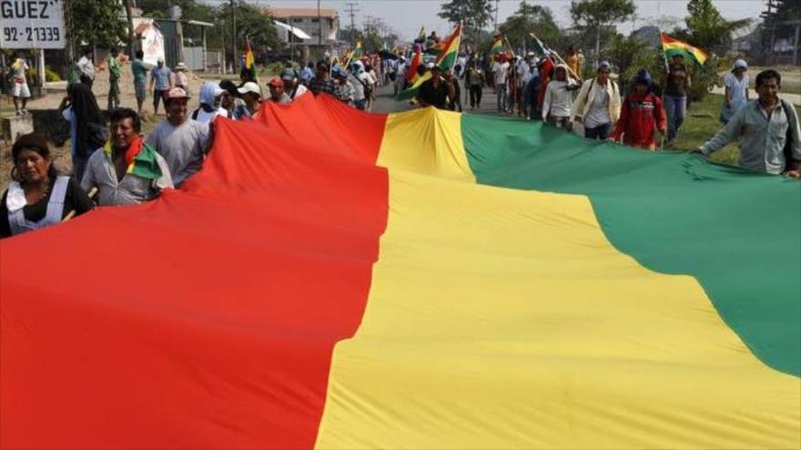 Manifestantes progubernamentales transportan una enorme bandera boliviana en Santa Cruz, 2017.