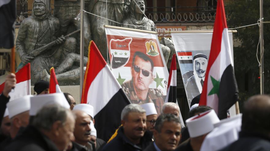 Residentes de los ocupados altos del Golán protestan contra la usurpación de esta región por Israel portando fotos del presidente sirio, Bashar al-Asad, 14 de febrero de 2018.