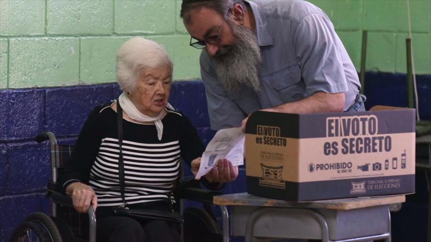 Una anciana trata de depositar su voto en un colegio electoral en San José, capital de Costa Rica, 4 de febrero de 2018.