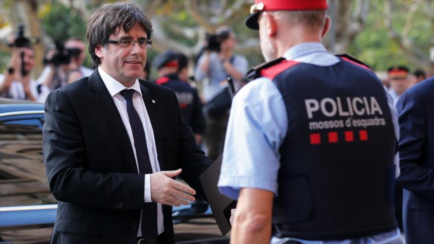 El entonces presidente de Cataluña, Carles Puigdemont, saluda a un policía catalán.