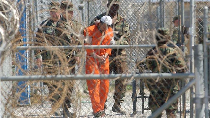 Soldados estadounidenses acompañan a un detenido en la cárcel de Guantánamo.