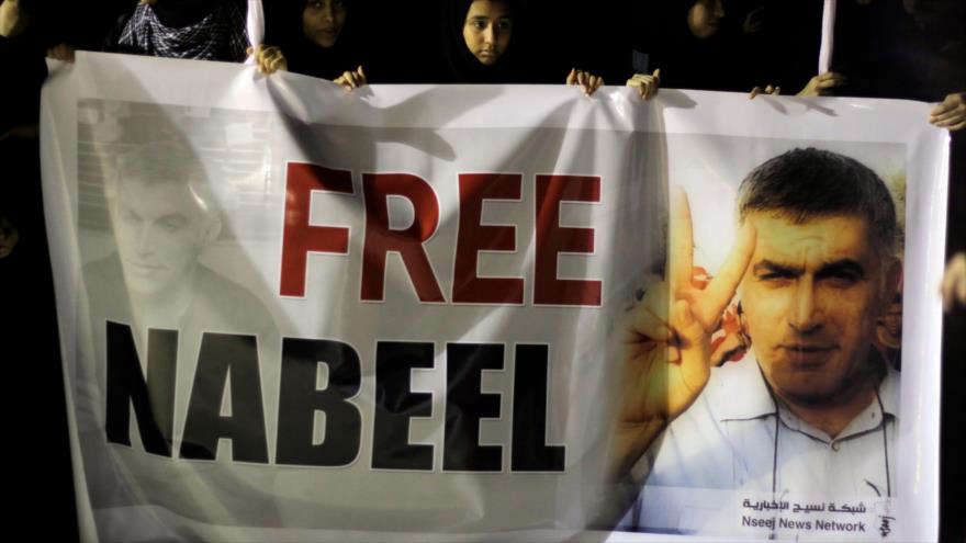 Un grupo de manifestantes porta un cartel, pidiendo la liberación del destacado activista bahreiní Nabil Rayab.