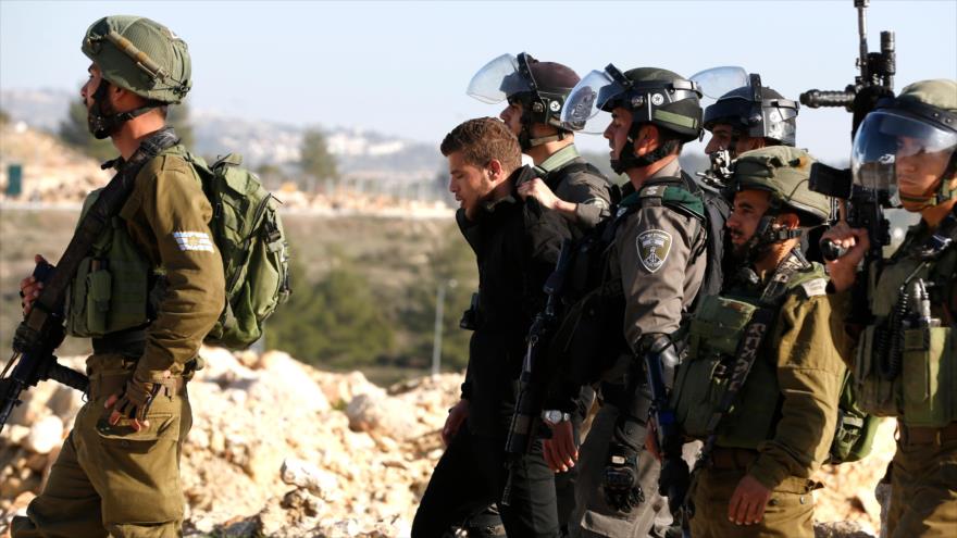 Fuerzas israelíes detienen a un joven palestino durante una manifestación en la ocupada Cisjordania, 13 de enero de 2018.