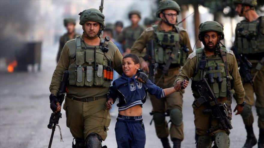Soldados israelíes detienen a un menor palestino durante una protesta en la ocupada Cisjordania.
