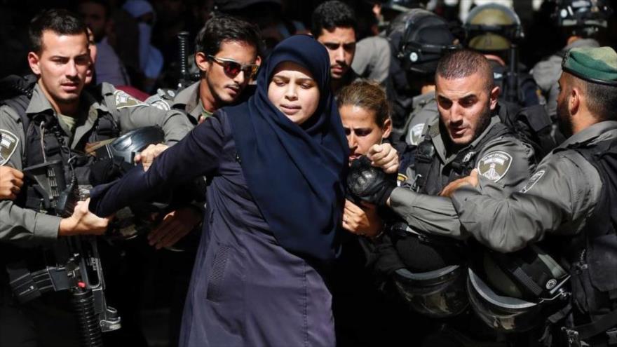 Fuerzas israelíes detienen a una mujer palestina en protestas en Al-Quds (Jerusalén).