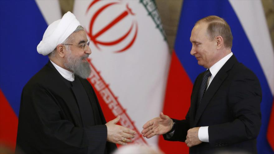 El presidente ruso, Vladimir Putin (dcha), y su homólogo iraní, Hasan Rohani, se van a estrechar la mano en un encuentro en Moscú, 28 de marzo de 2017.