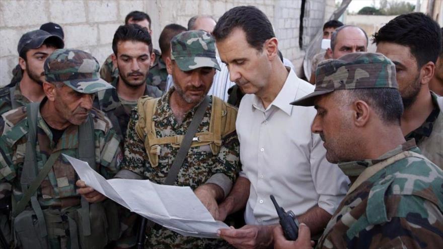 El presidente sirio, Bashar al-Asad, observa un mapa junto a varios militares.