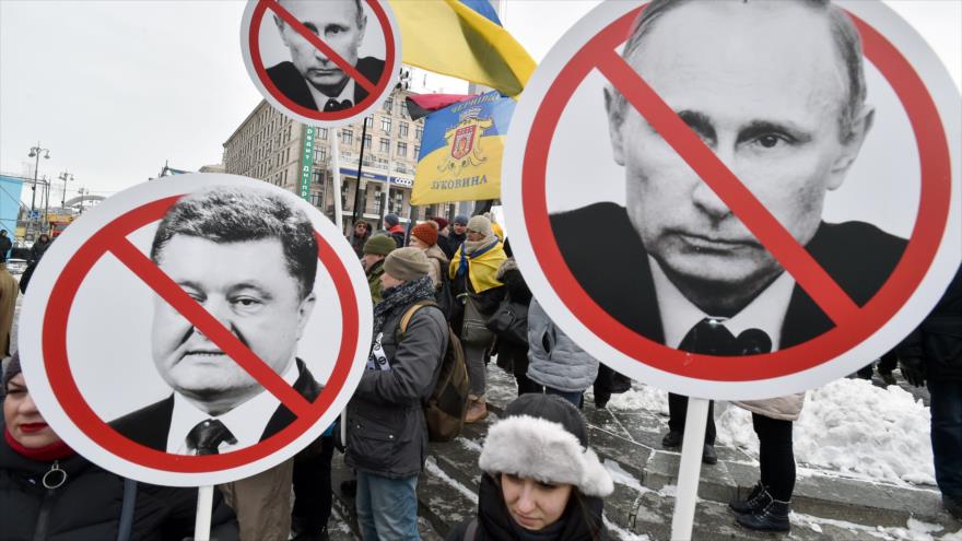 Manifestantes ucranianos muestran en Kiev (capital) su rechazo a su presidente, Petro Poroshenko, y al de Rusia, Vladimir Putin, 18 de marzo de 2018.