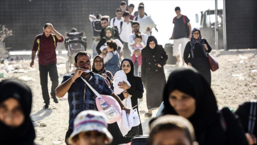 Refugiados sirios llegan a la puerta de cruce de Oncupinar, cerca de la ciudad turca de Kilis, rumbo a Siria, 27 de agosto de 2017.