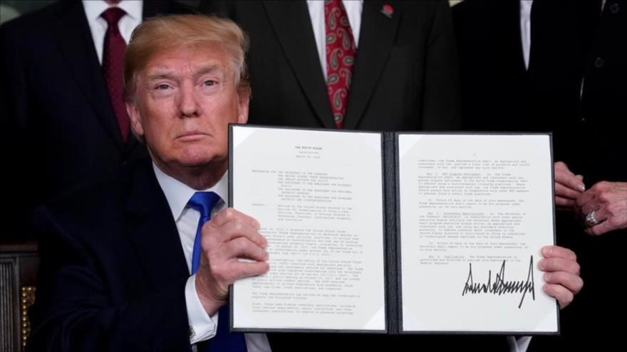 El presidente estadounidense, Donald Trump, muestra su firma en un mermorándum sobre China, 22 de marzo de 2018.