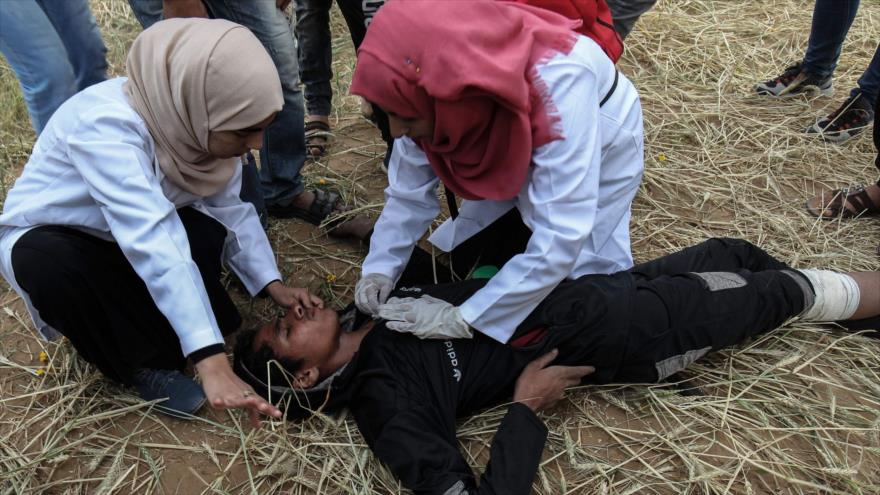 Médicas voluntarias ayudan a un manifestante palestino herido durante una represión israelí en Gaza, 3 de abril de 2018.
