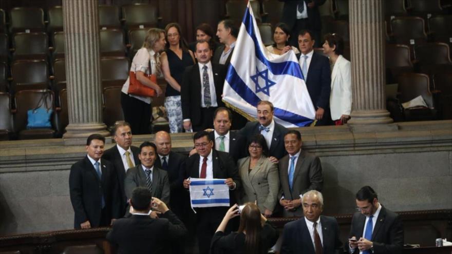 Los diputados del Congreso de Guatemala levantan la bandera del régimen de Israel, 19 de abril de 2018.