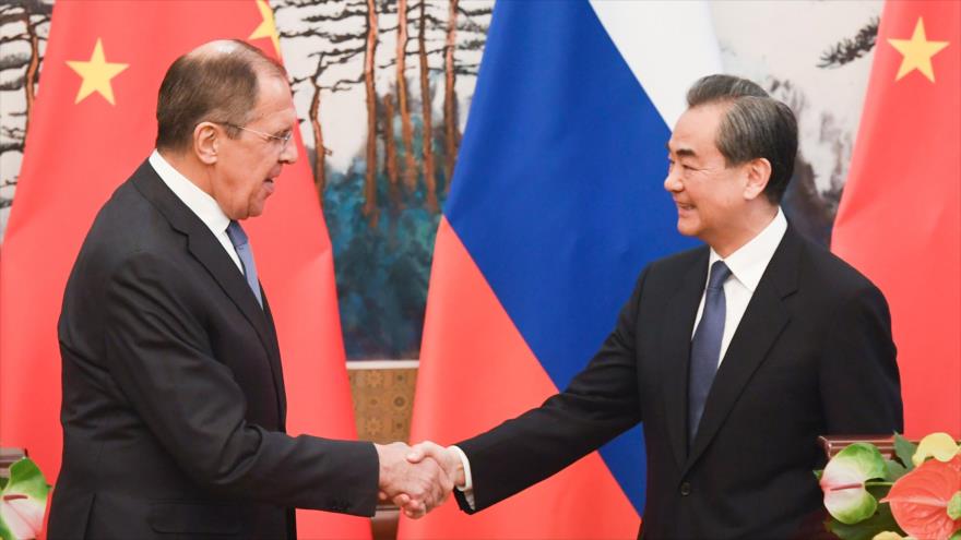 Los ministros de Exteriores de Rusia y China, Serguéi Lavrov (izda), y Wang Yi, se dan la mano al finalizar una conferencia de prensa en Pekín, 23 de abril de 2018