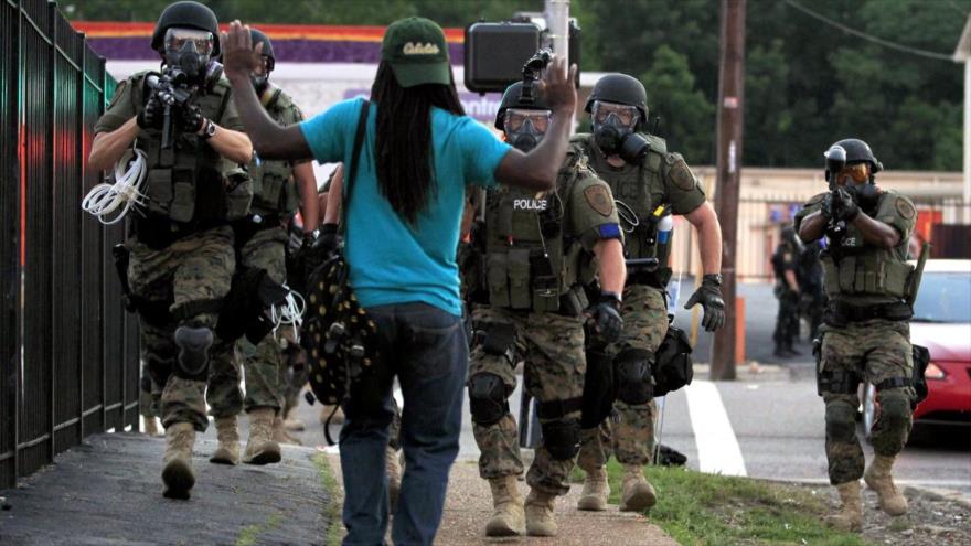 La policía antidisturbios de EE.UU. se enfrenta a un hombre en la ciudad de Ferguson, en el estado estadounidense de Misuri, 11 de agosto de 2014.