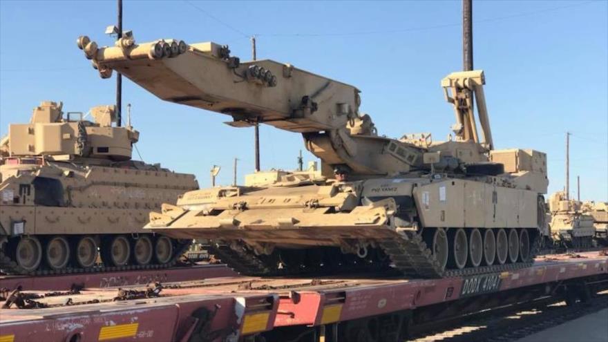 Vehículos militares y tanques estadounidenses cargados en un tren.