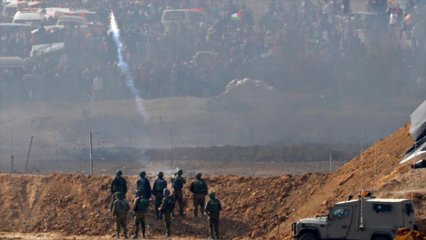 Soldados israelíes lanzan gas lacrimógeno contra los manifestantes palestinos en la Franja de Gaza, 13 de abril de 2018.