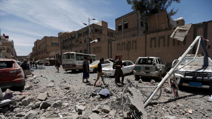 Yemeníes inspeccionan los alrededores de la oficina de la Presidencia en la capital, Saná, tras dos ataques aéreos saudíes, 7 de mayo de 2018.
