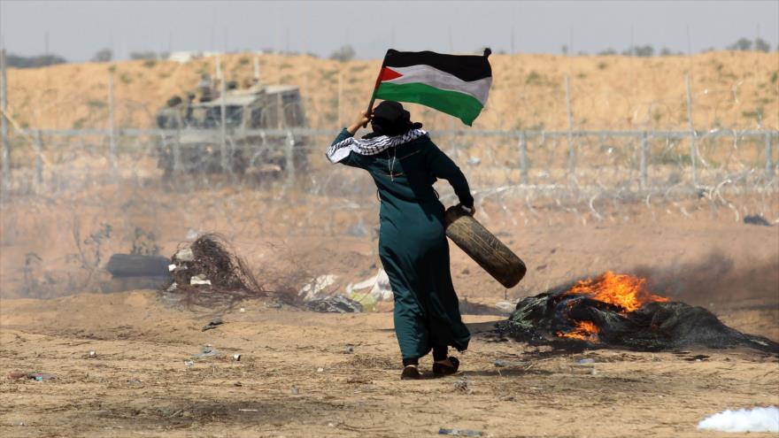 Una mujer palestina ondea la bandera de su país en la asediada Franja de Gaza, 11 de mayo de 2018.