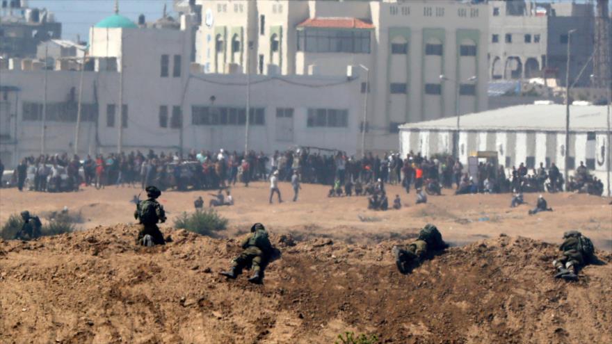 Soldados israelíes mantienen posición para disparar contra manifestantes palestinos en la Franja de Gaza, 14 de mayo de 2018.