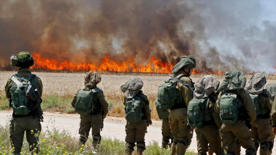Soldados israelíes apuntan con sus armas contra manifestantes palestinos en la Franja de Gaza, 14 de mayo de 2018.