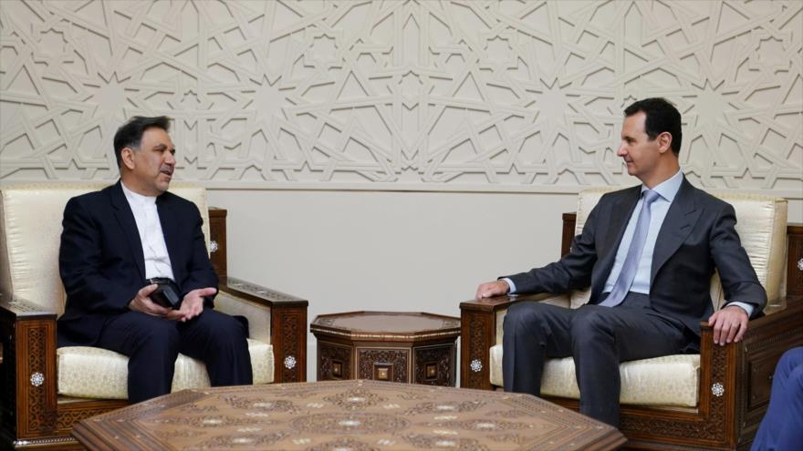 El presidente de Siria, Bashar al-Asad (dcha.) y el ministro iraní de Transporte y Desarrollo Urbano, Abás Ajundi, en Damasco, 18 de mayo de 2018.