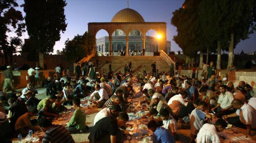 Palestinos abren su ayuno fuera de la Mezquita Al-Aqsa, en la ciudad palestina de Al-Quds (Jerusalén).