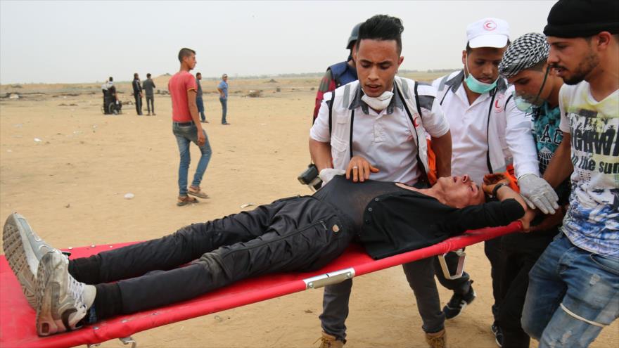 Manifestantes palestinos llevan a un hombre herido en una manifestación en Gaza, 4 de mayo de 2018.