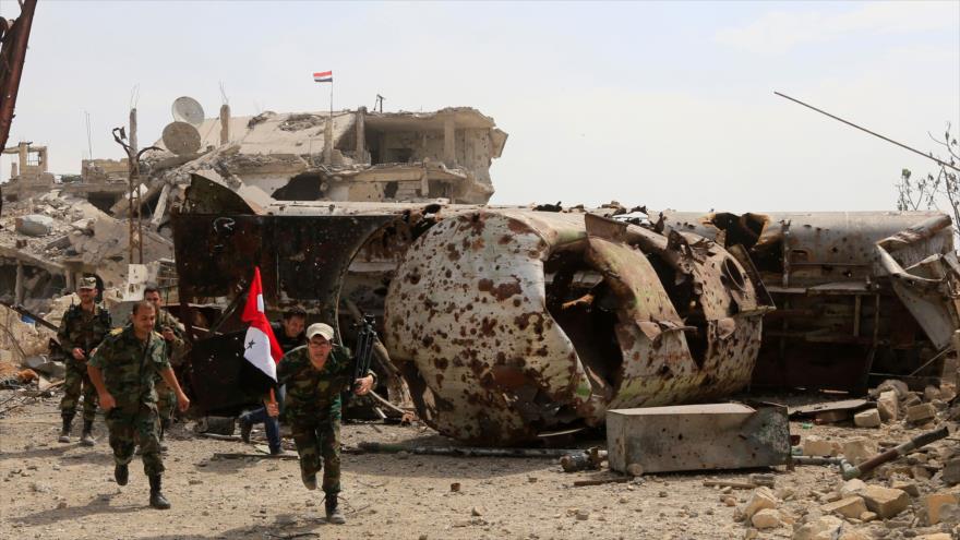 Las fuerzas del Ejército sirio corren para cubrirse de los disparos de francotiradores de Daesh en el campo de Al-Yarmuk, 29 de abril de 2018.