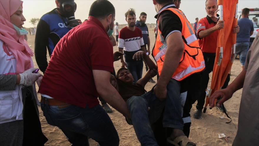 Paramédicos socorren a un manifestante palestino herido en la Franja de Gaza, 25 de mayo de 2018.